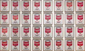 Grid of framed Campbell's Soup cans in a wall installation, red-and-white labels repeated in neat rows.