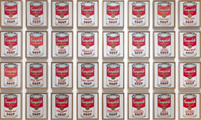 Grid of framed Campbell's Soup cans in a wall installation, red-and-white labels repeated in neat rows.